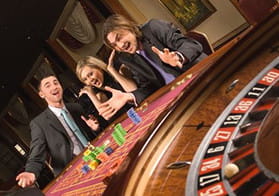 3 personas contentas jugando la ruleta
